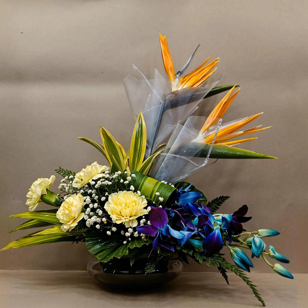 Floral Arrangement made with Birds of Paradise, Carnations and Orchids in Fish Bowl