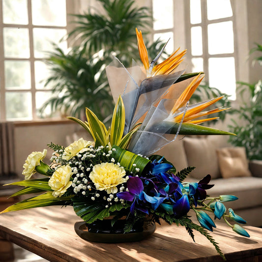 Floral Arrangement made with Birds of Paradise, Carnations and Orchids in Fish Bowl